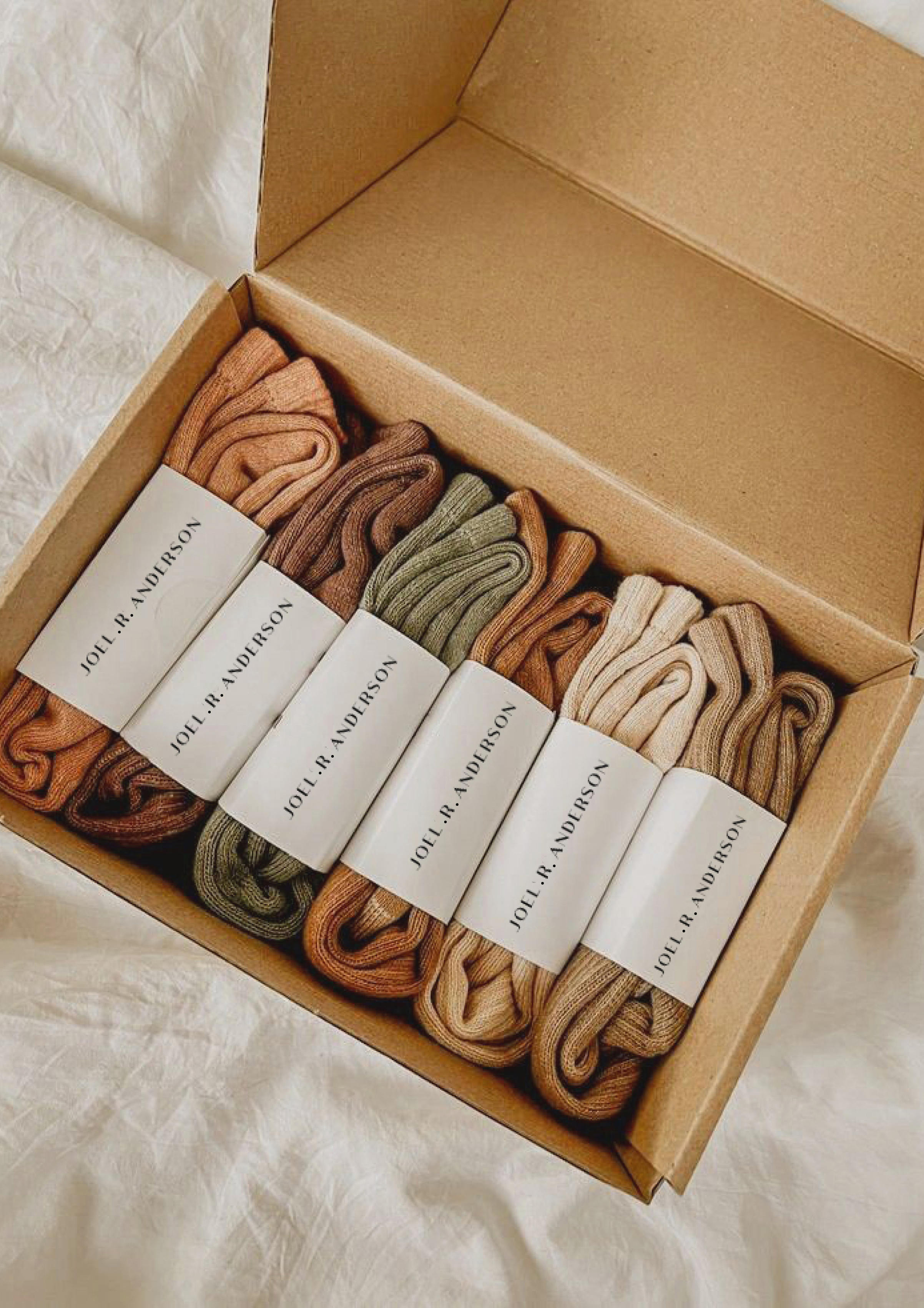 Garments rolled and wrapped in a branded box